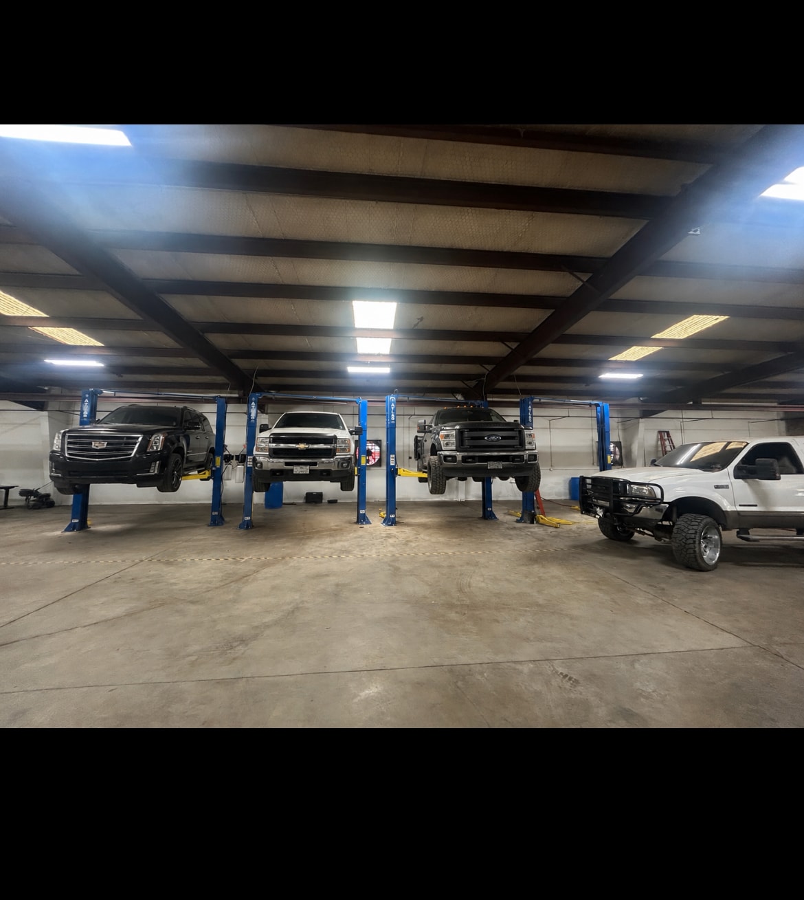Five Star Engine Rebuilders shop floor with multiple vehicles on lifts